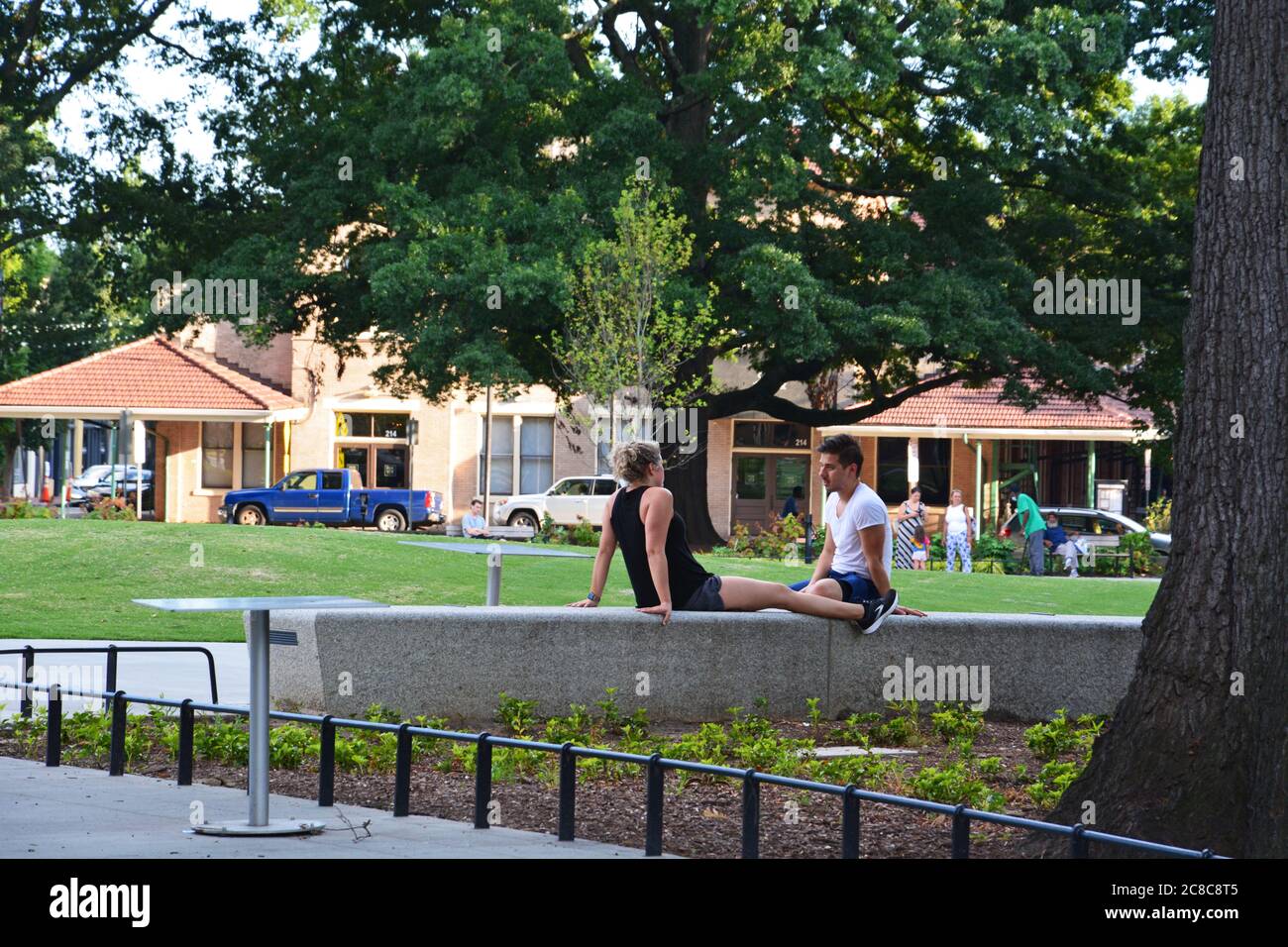 A couple sit in Moore Square park in downtown Raleigh North Carolina. Stock Photo