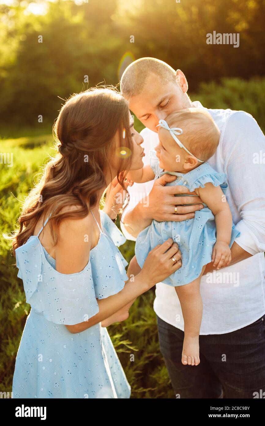 Little cute baby girl with mom and dad, beautiful daughter sitting ...