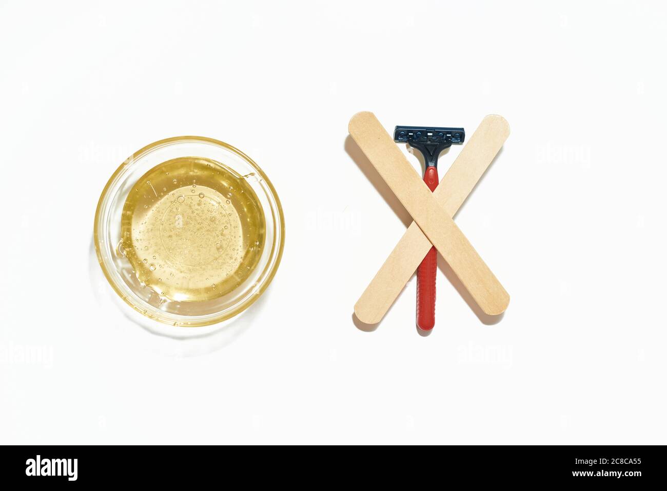 The razor VS wax. Razor against wax on the white background Stock Photo