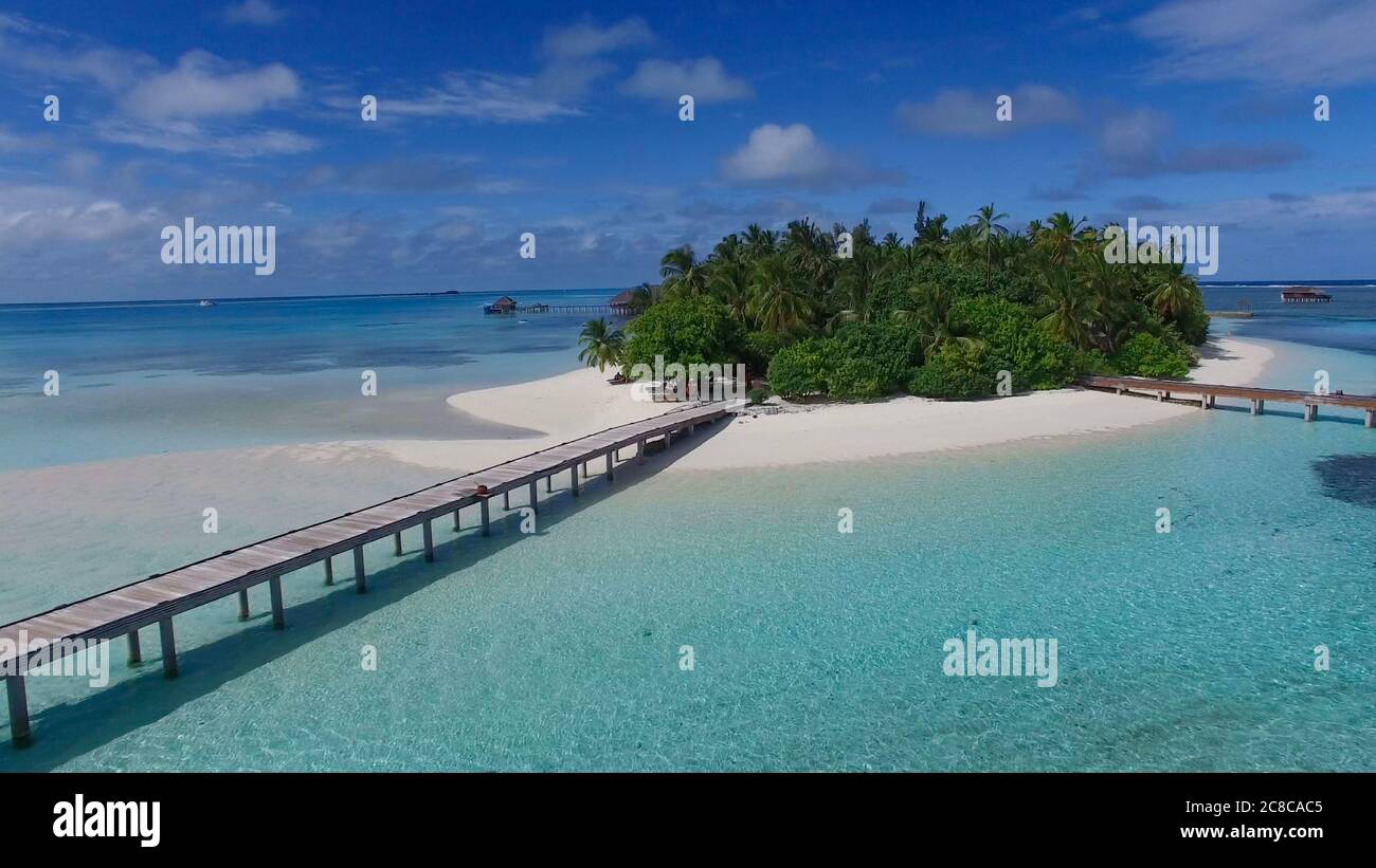 Aerial photo of Maldivian paradise island with white sand and over water villas. Green palm trees and turquoise  water. Concept: travel agency, paradi Stock Photo