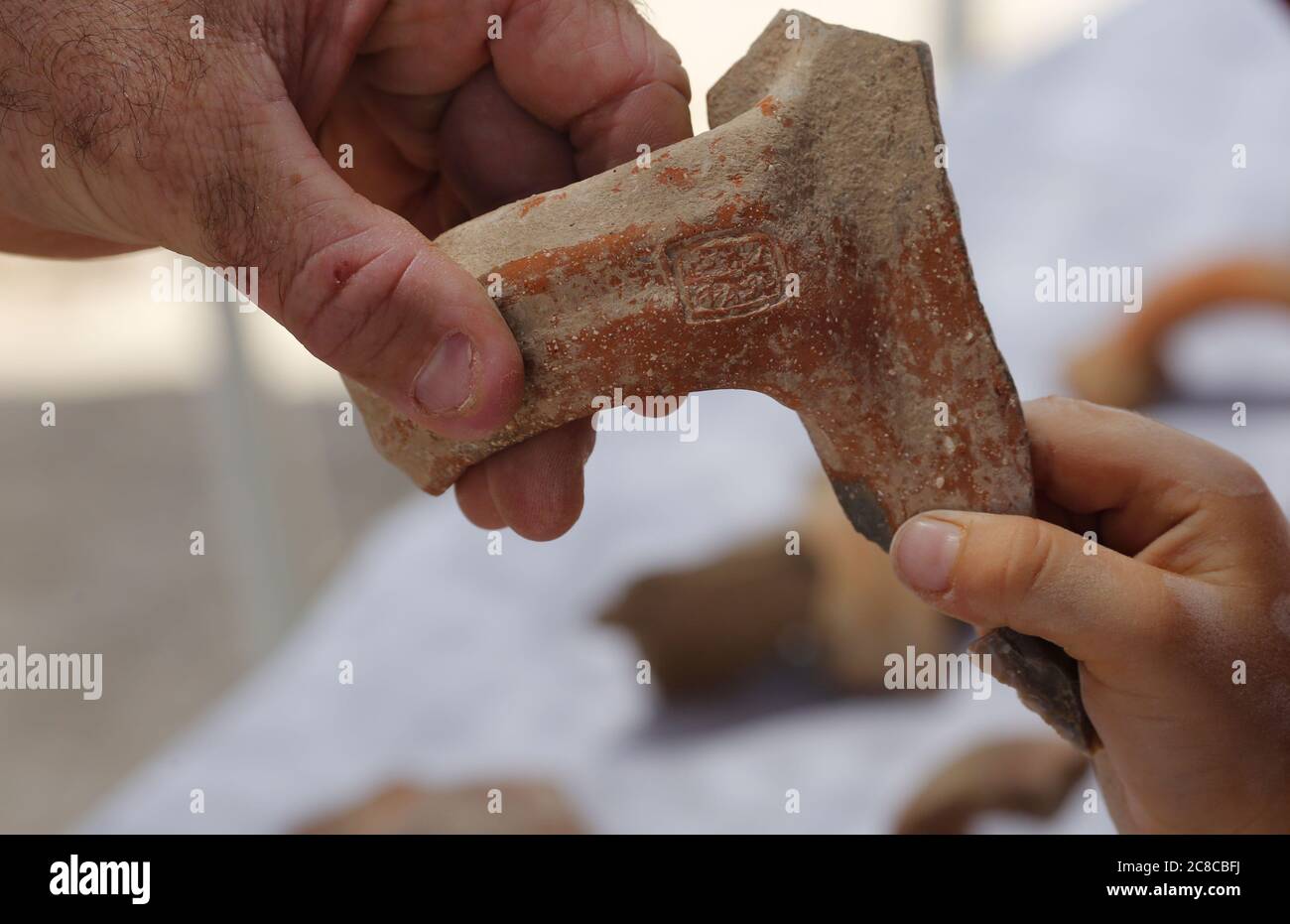 (200723) -- JERUSALEM, July 23, 2020 (Xinhua) -- An archeologist shows a seal impression bearing ancient Hebrew script unearthed at an excavation site in Jerusalem on July 22, 2020. Israeli archaeologists have discovered a 2,700-year-old administrative storage center in Jerusalem, the Israel Antiquities Authority (IAA) said on Wednesday. (Photo by Gil Cohen Magen/Xinhua) Stock Photo