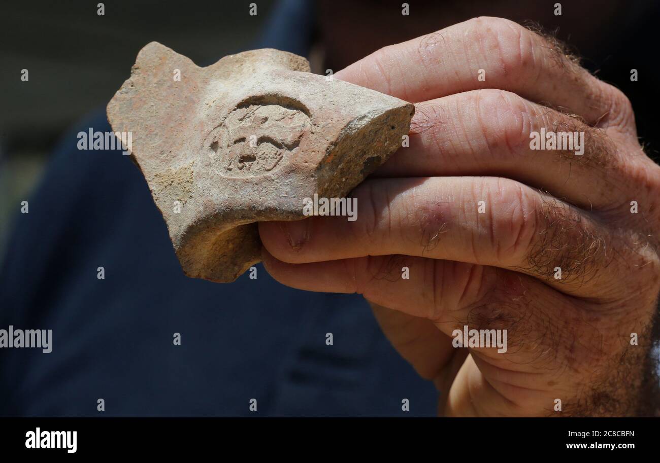 (200723) -- JERUSALEM, July 23, 2020 (Xinhua) -- An archeologist shows a seal impression bearing ancient Hebrew script unearthed at an excavation site in Jerusalem on July 22, 2020. Israeli archaeologists have discovered a 2,700-year-old administrative storage center in Jerusalem, the Israel Antiquities Authority (IAA) said on Wednesday. (Photo by Gil Cohen Magen/Xinhua) Stock Photo