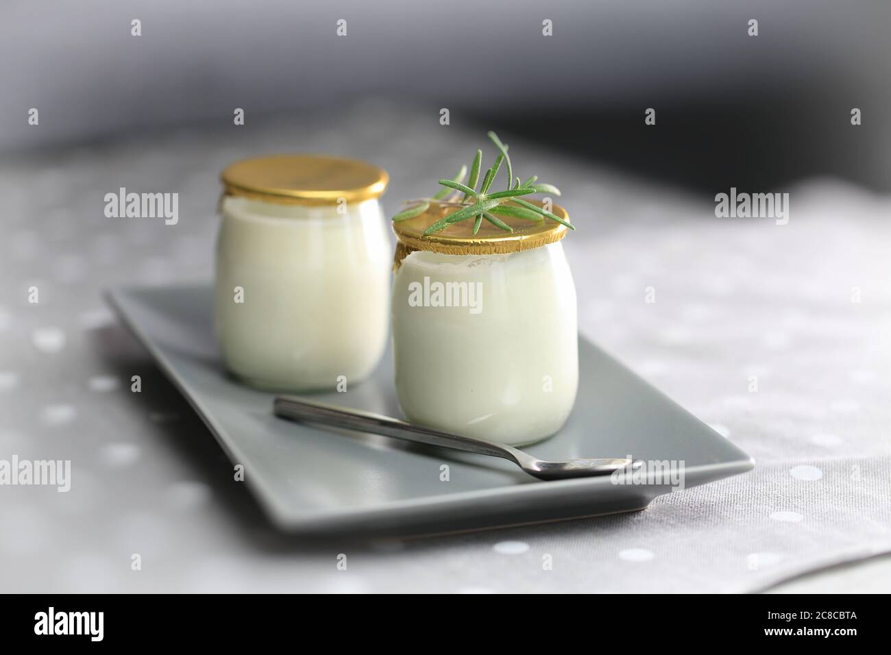 Yogurt in a glass jar with a spoon. Healthy food for breakfast, dairy product Stock Photo