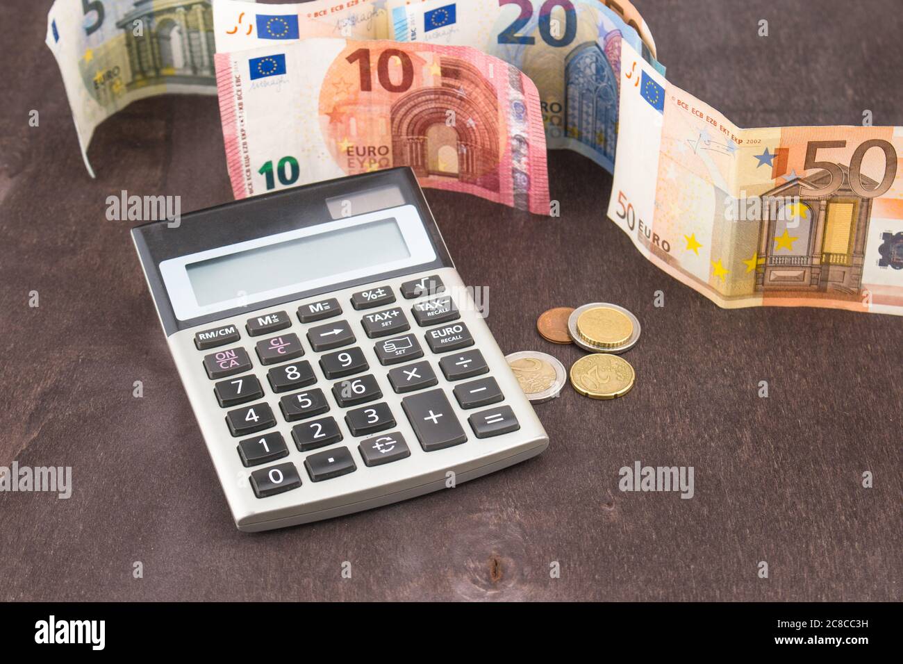 Banknotes and coins with calculator. Euro banknotes on wooden background.  Photo for tax, profit and costing. 50 euro, 20 euro, 10 euro. Money and fina  Stock Photo - Alamy