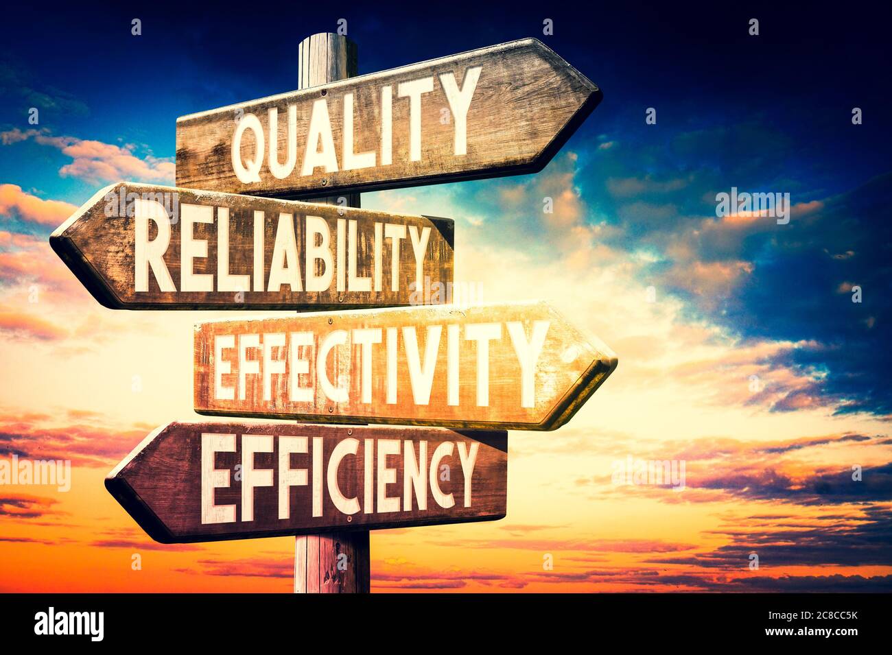 Quality, reliability, effectivity, efficiency - wooden signpost, roadsign with four arrows Stock Photo