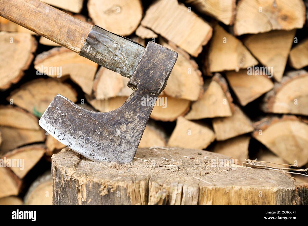 old axe on stump against logs Stock Photo
