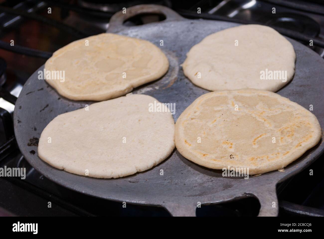 Nutritious handmade corn tortilla cooked on a metal griddle on a gas stove  in a Guatemalan home Stock Photo - Alamy