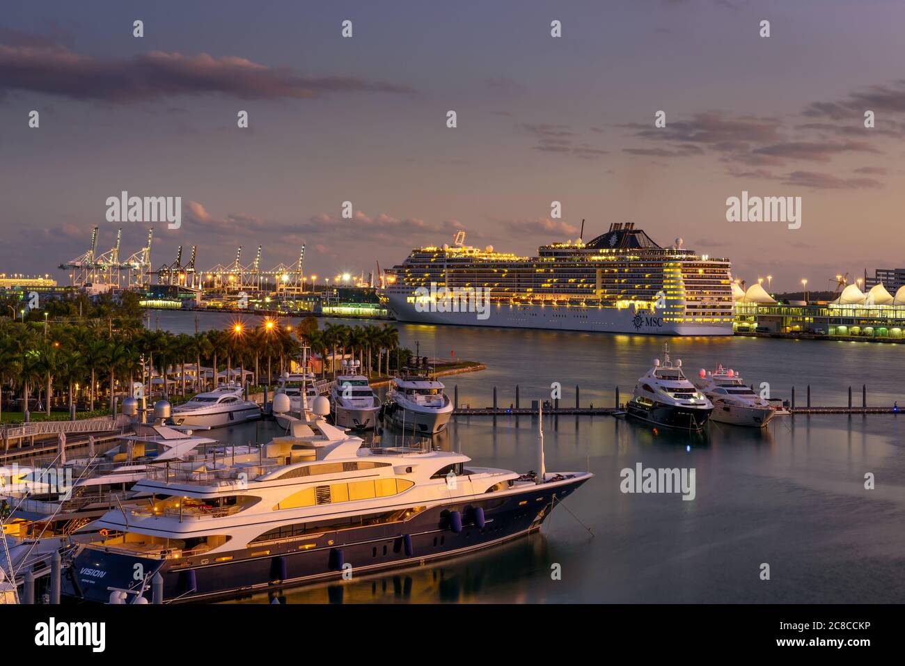 Miami, Florida, USA - January 8, 2020 : MSC Divina cruise ship in the Port of Miami at sunset with multiple luxury yachts in the foreground. Stock Photo