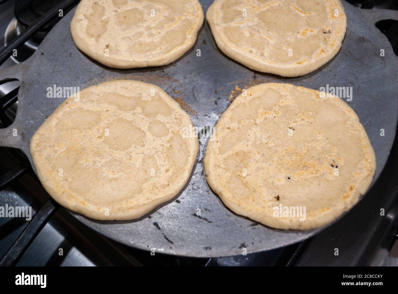 Nutritious handmade corn tortilla cooked on a metal griddle on a gas