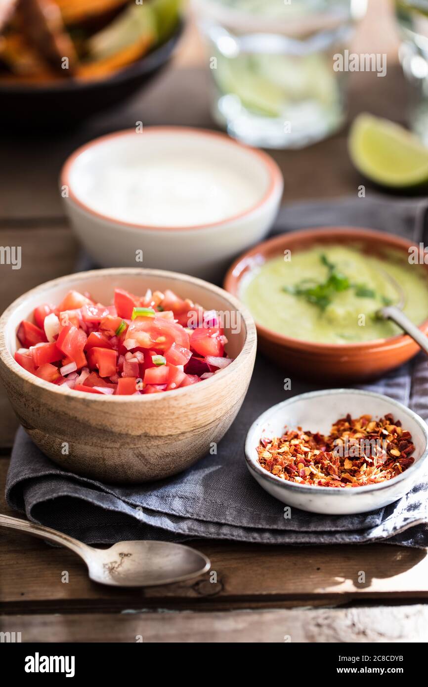 Mexican food dips, salsa, chilli flakes, sour cream, potato wedges