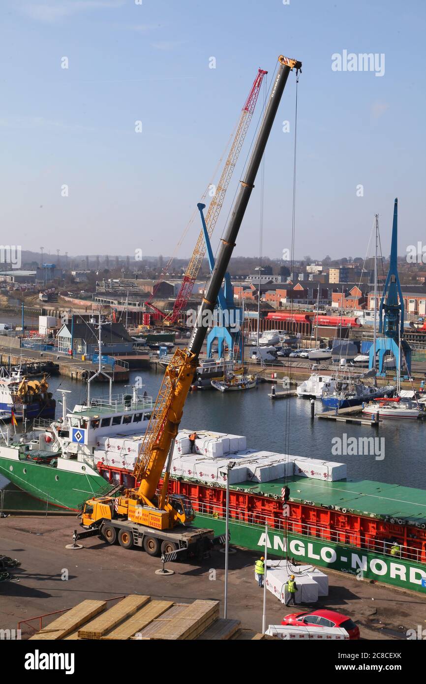 Timber ship being unloaded Stock Photo