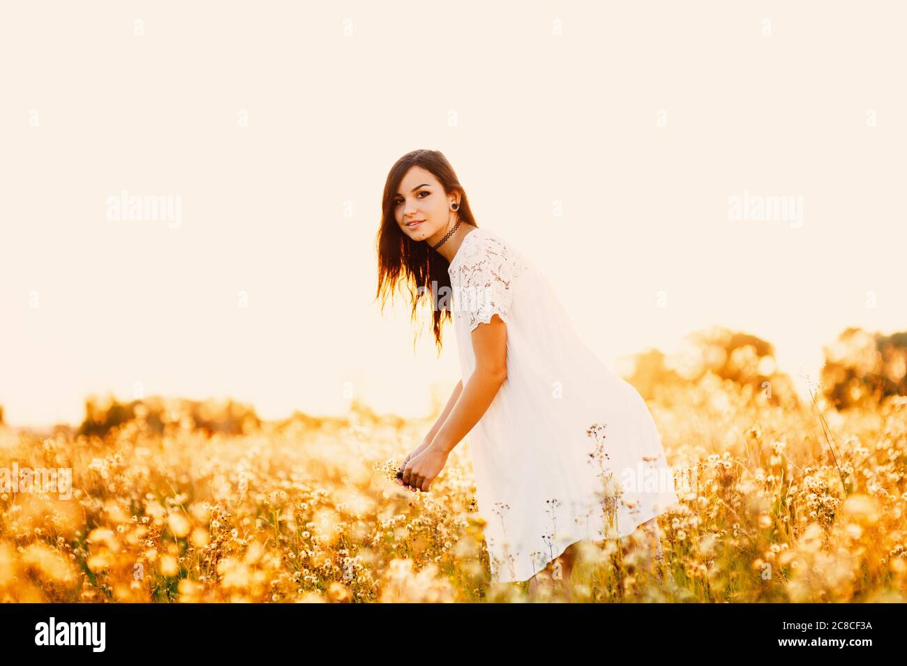 Beautiful Tender lovely young woman with long hair in flower field in ...