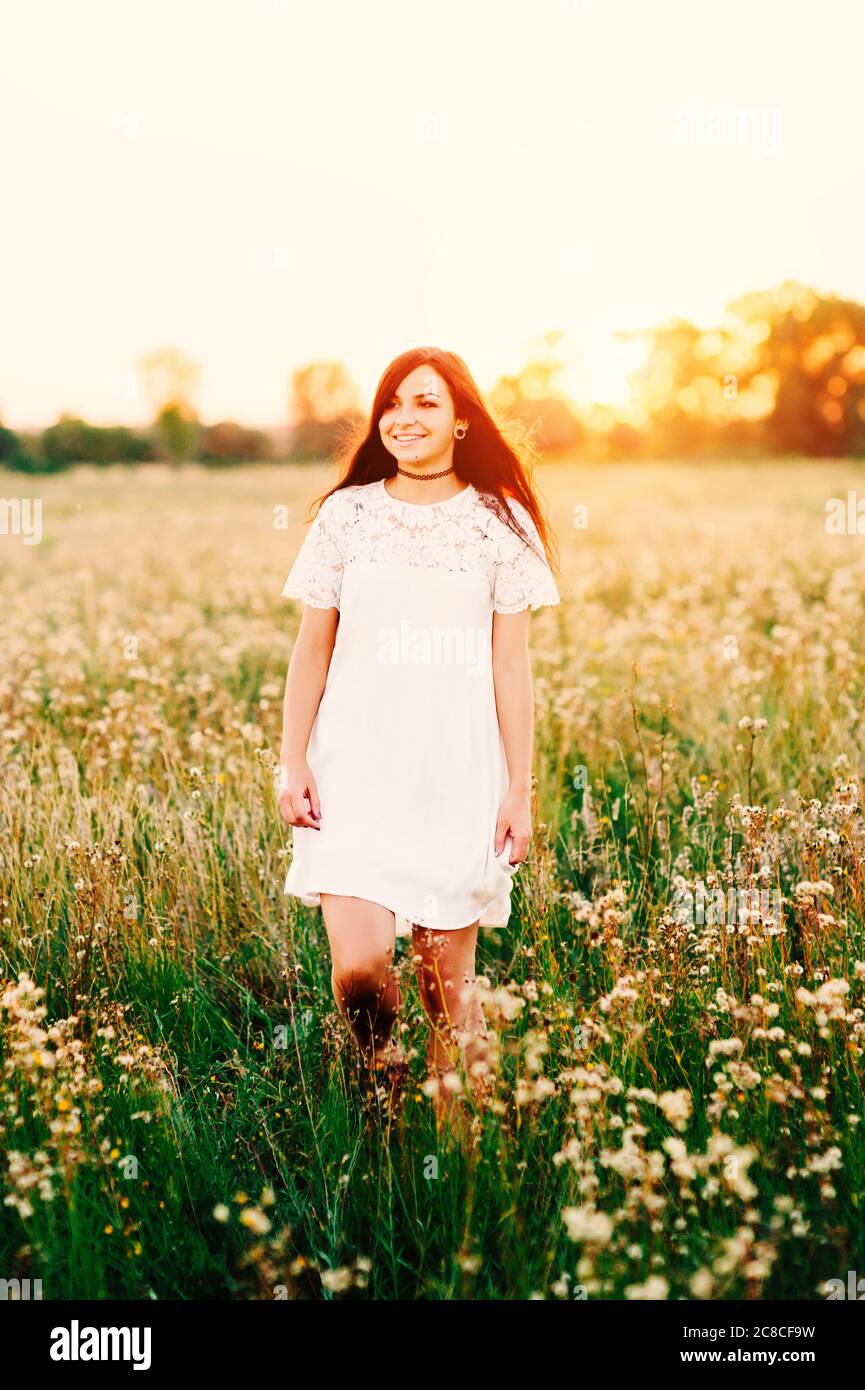 Beautiful Tender lovely young woman with long hair in flower field in ...