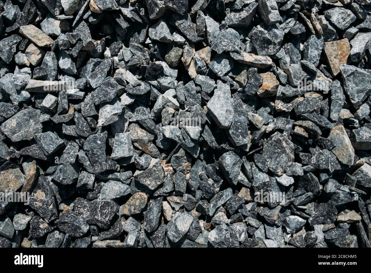 Rough stones, crushed stone, granite gravel close-up. The rough texture of the stone. Building material background. Texture Stock Photo