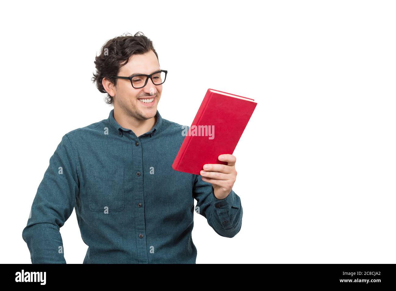 Happy young man, student, looking interested at a red book in his hand, reading the textbook title, isolated on white background. Education concept, l Stock Photo