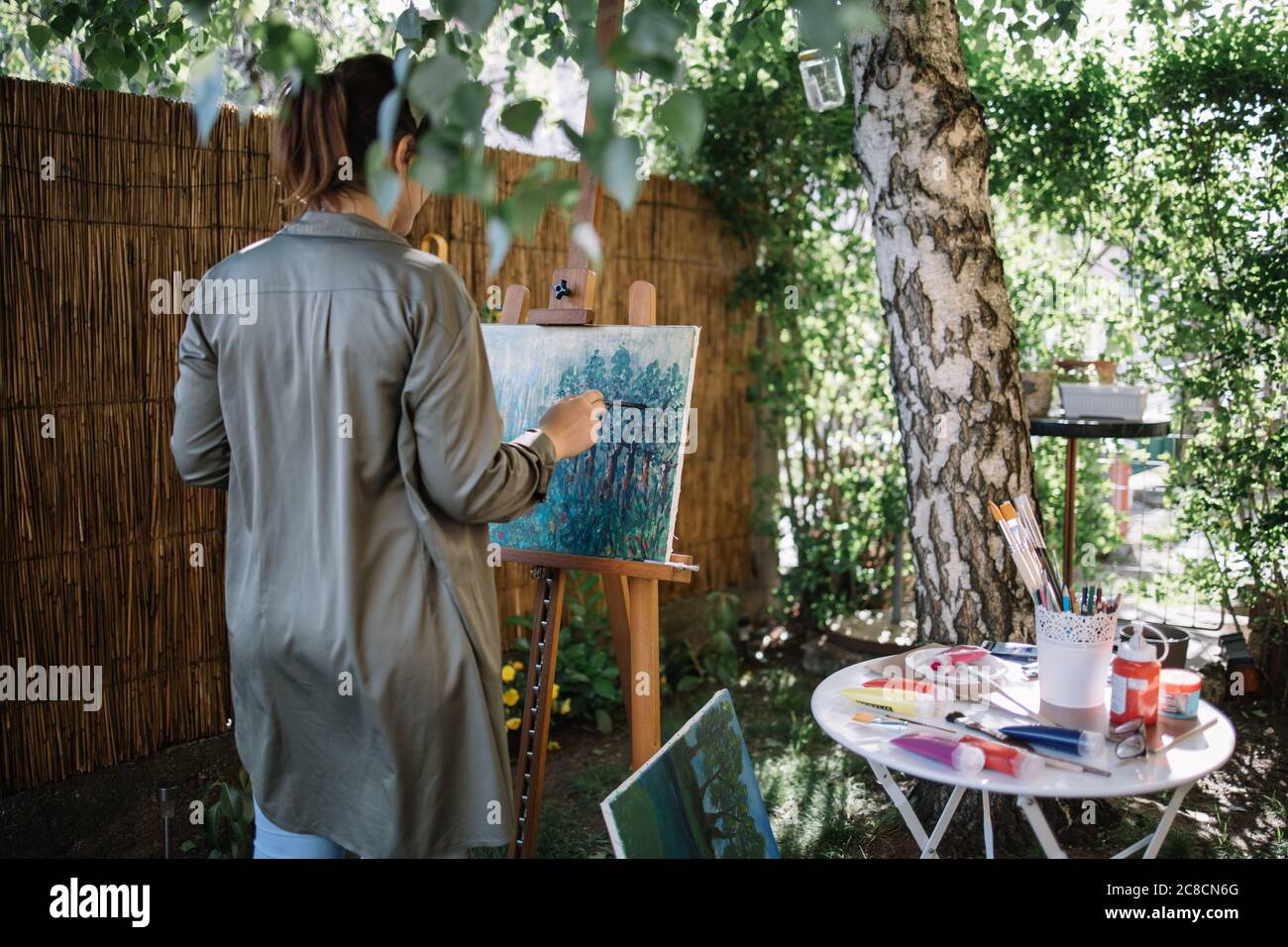 Female artist painting on a canvas in outdoor studio Stock Photo - Alamy