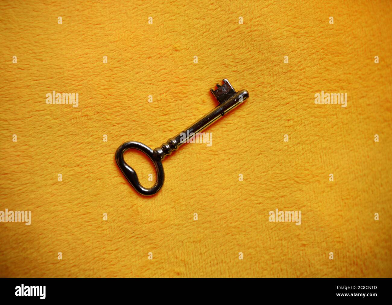 Simple big key on yellow background Stock Photo