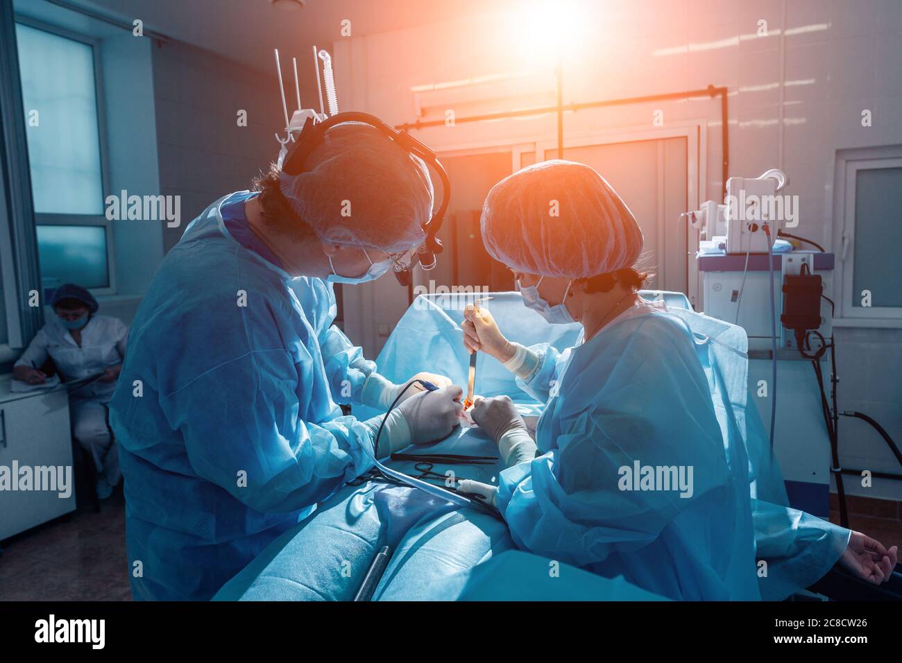 two veterinarian surgeons in operating room take with art lighting and blue filter Stock Photo