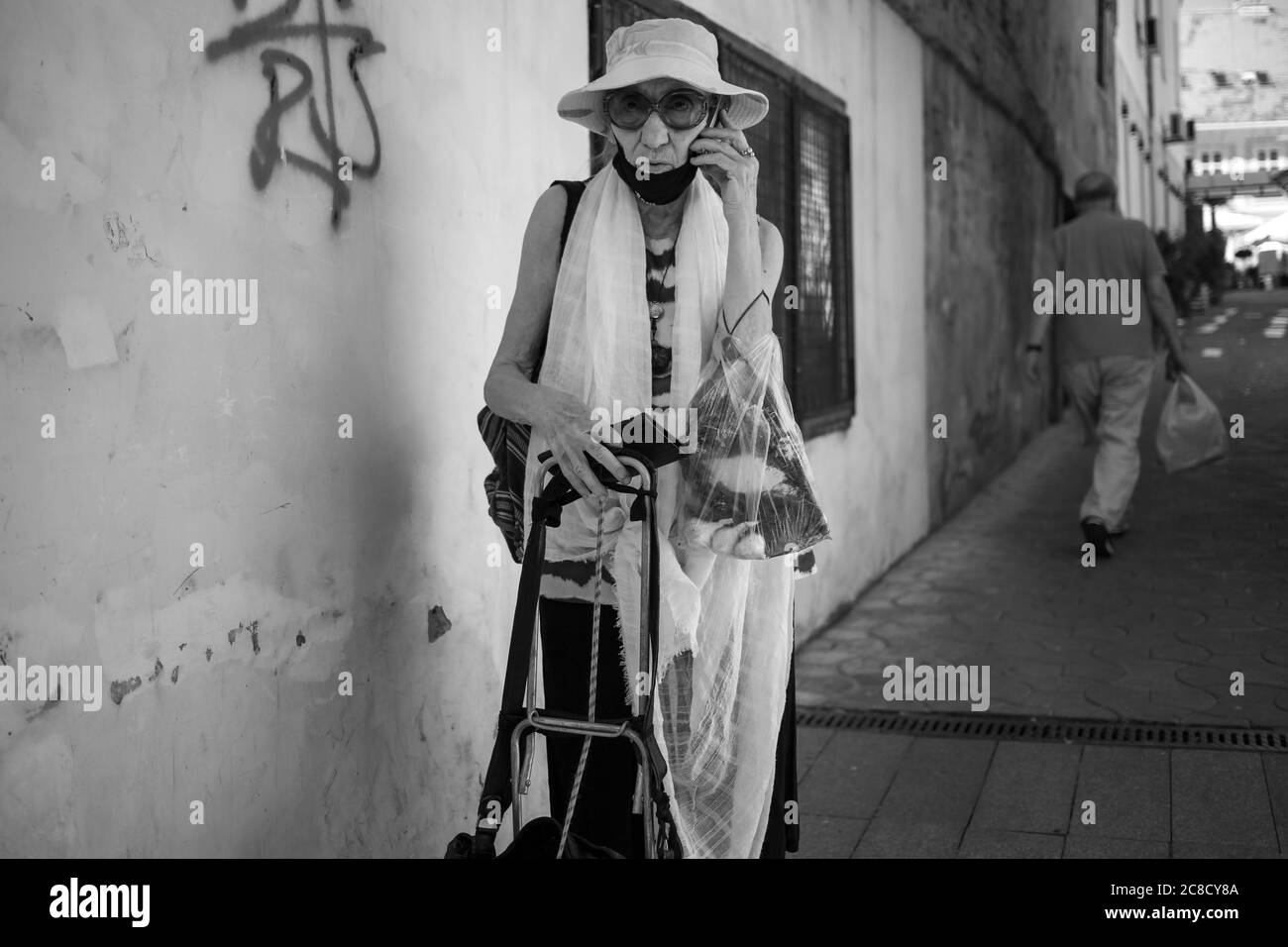 Belgrade, Serbia, Jul 9, 2020: An elderly lady standing on the street and talking by phone (B/W) Stock Photo