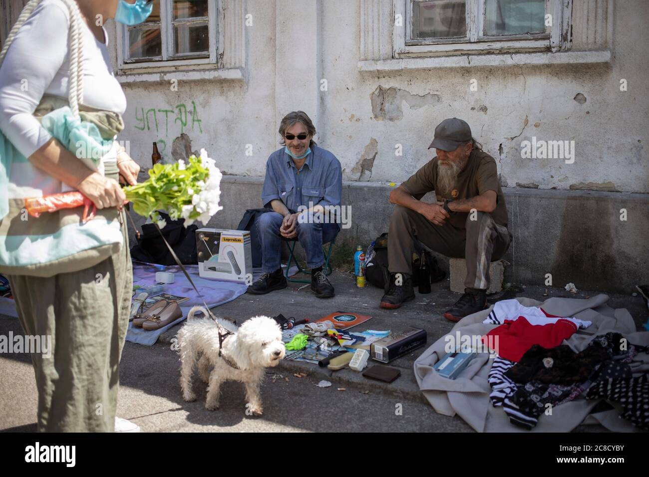 Belgrade, Serbia, Jul 9, 2020: Two vendors sitting in a shade at flea market Stock Photo