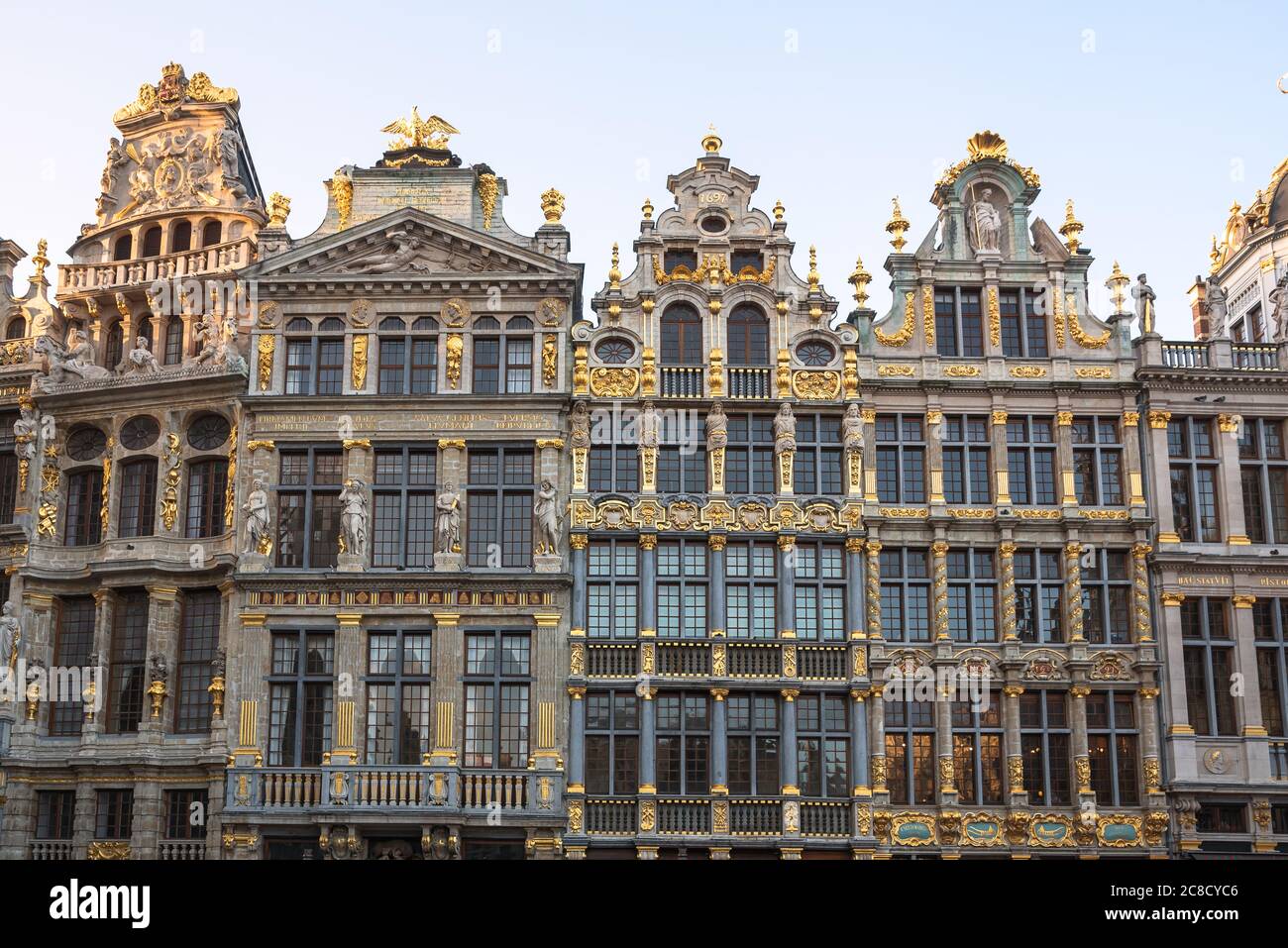 View of the richly decorated facades of some historic guildhouses in Grand Place in Brussels old town at sunset Stock Photo