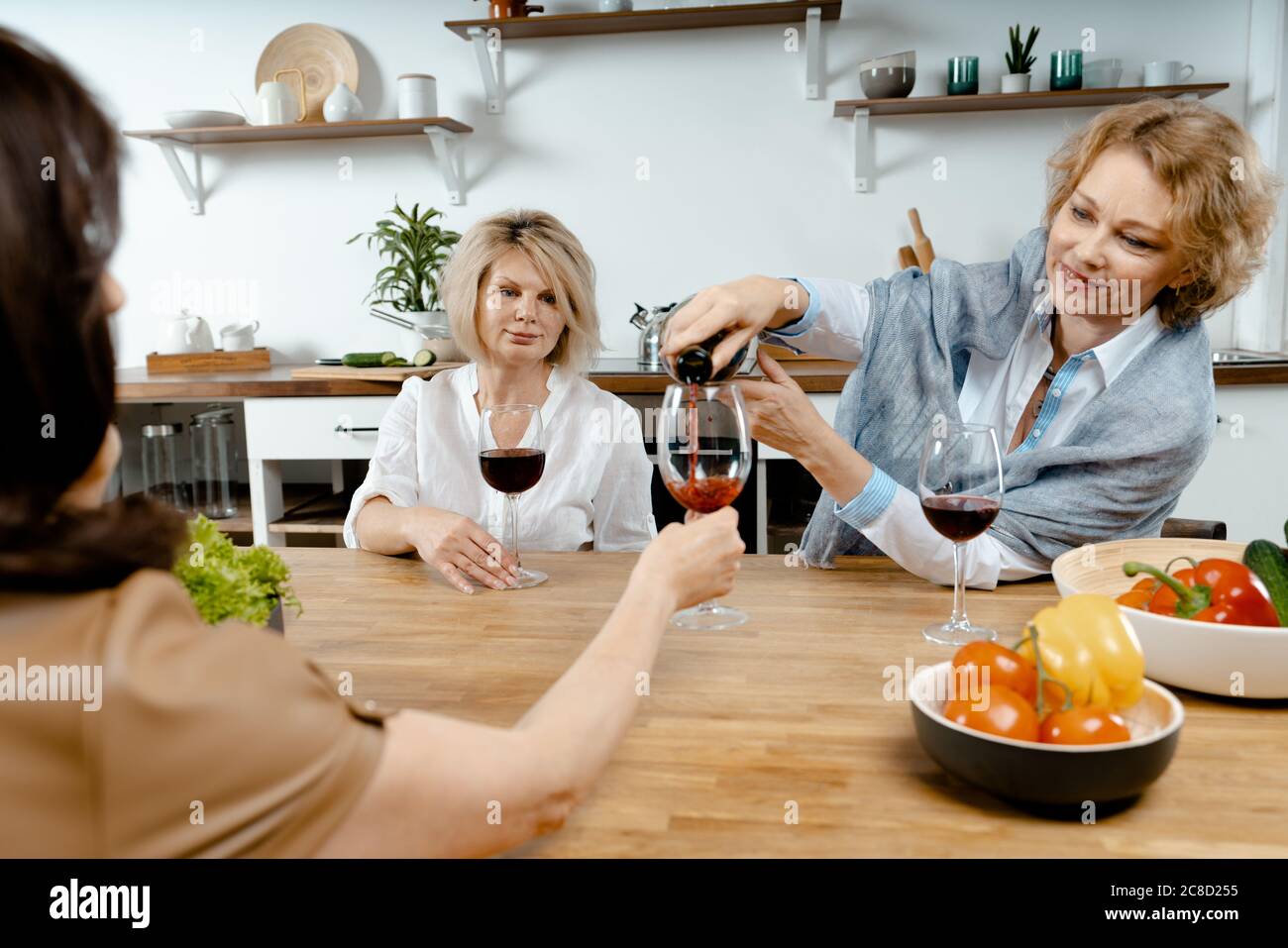 Senior Ladies Drinking Wine And Talking About News In Their Lives. Concept Of Active Lifestyle At Middle Age. Living Full Life. Natural Ageing Stock Photo