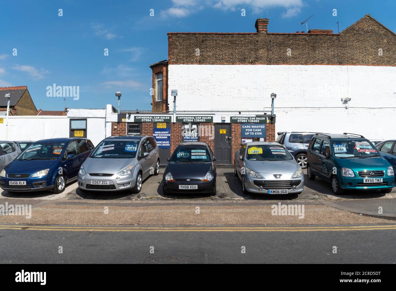 Back street outdoor car lot, vehicle sales in Westcliff on Sea, Southend, Essex, UK. Old, ageing budget cars. Cheap vehicles. Ford Ka. Peugeot Stock Photo