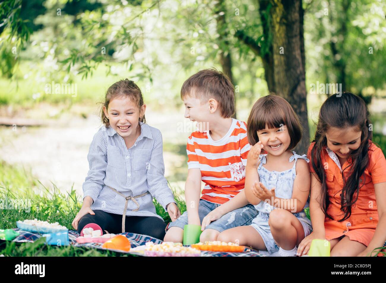 Group Of Smiling Children Relaxing In Park Stock Photo - Alamy