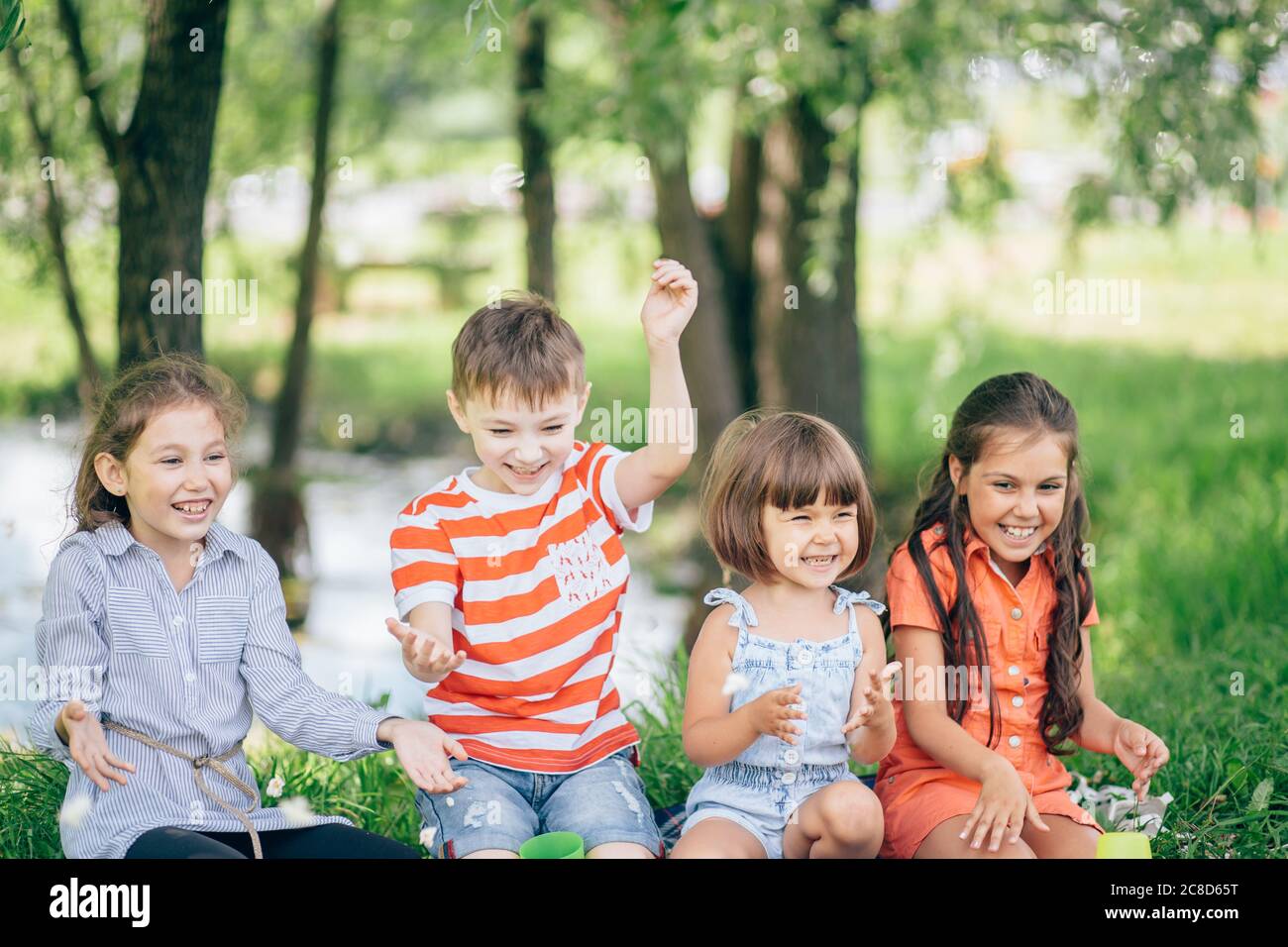 Group Of Smiling Children Relaxing In Park Stock Photo - Alamy