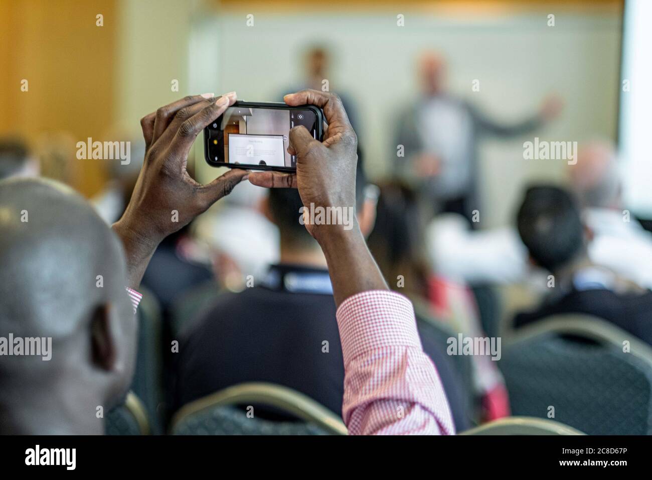Filming A Business Conference Event With A Smartphone Stock Photo