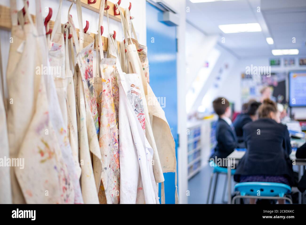 Aprons Handing Up in an Art Lesson at School Stock Photo