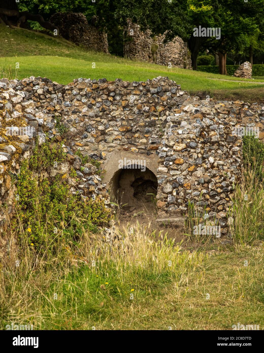 Tiny archway discovered in a flint stone ruined wall Stock Photo