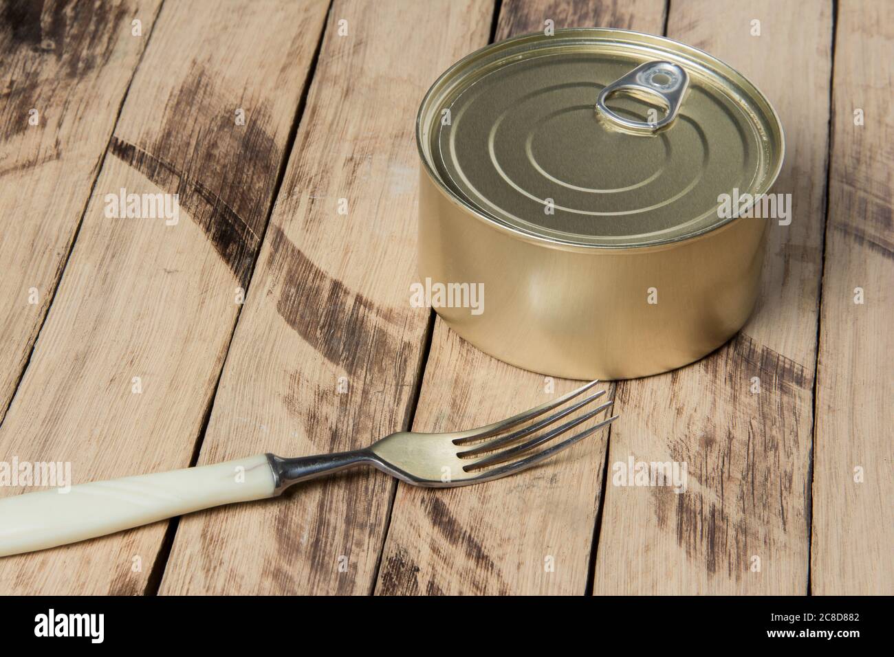 Food Can and Fork on a Wooden Table. Packaging, product. Storage of food for a long time. Stock Photo