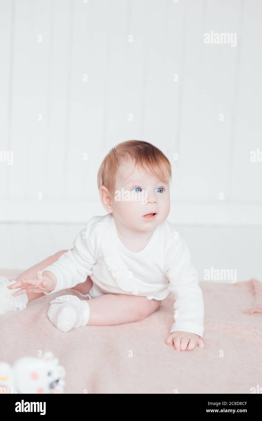 Cute baby boy on bed in room Stock Photo