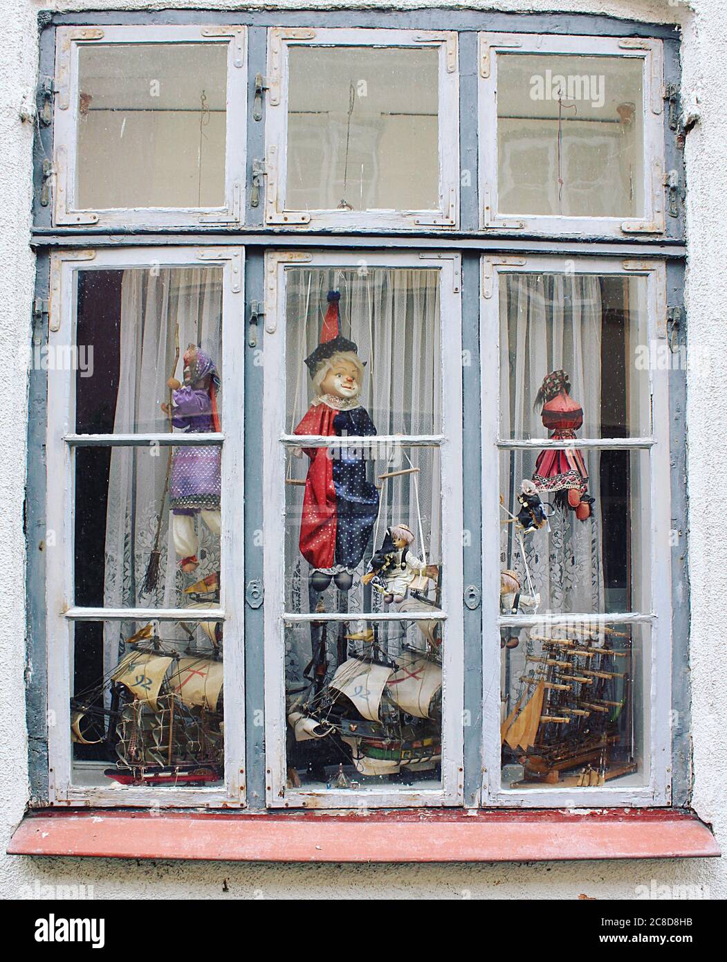 Old-fashioned window decorated with vintage puppets and ships in Luebeck, Germany. Stock Photo