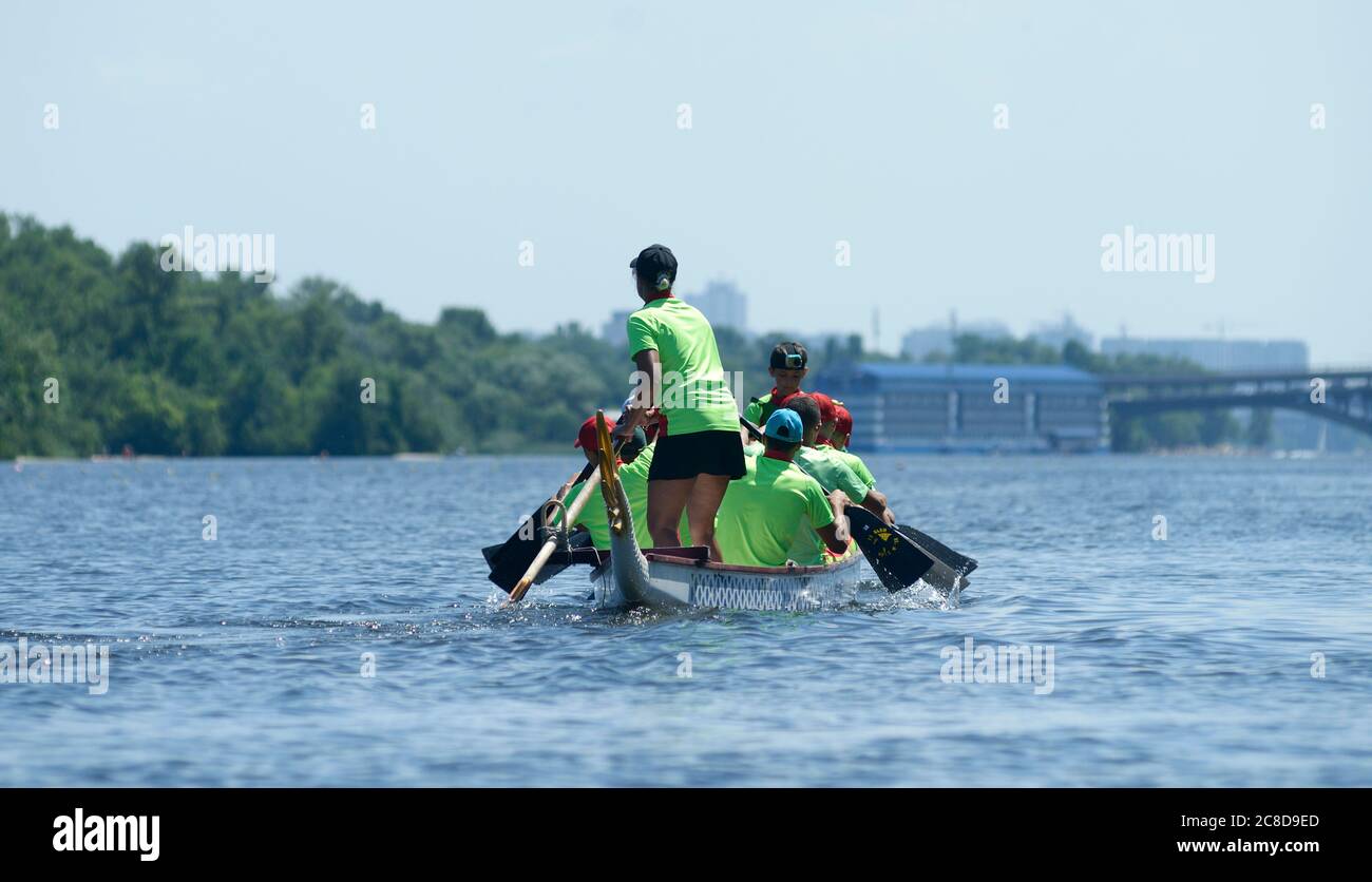 Oarsmen rowing a dragon boat on a river. Kiev oblast championship among amateurs Stock Photo