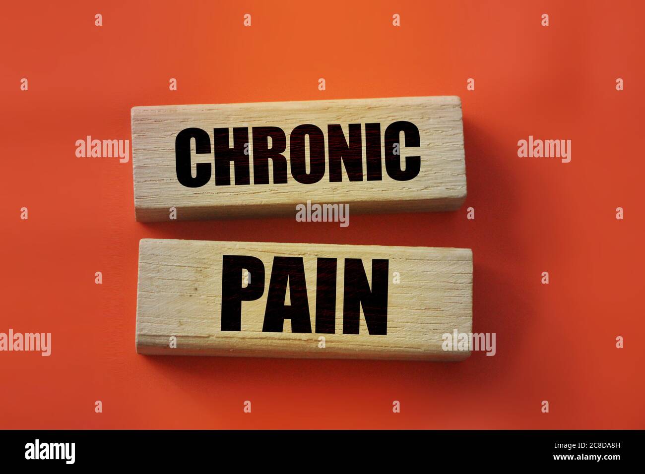 Chronic pain words on wooden blocks on red background. Medicine concept Stock Photo