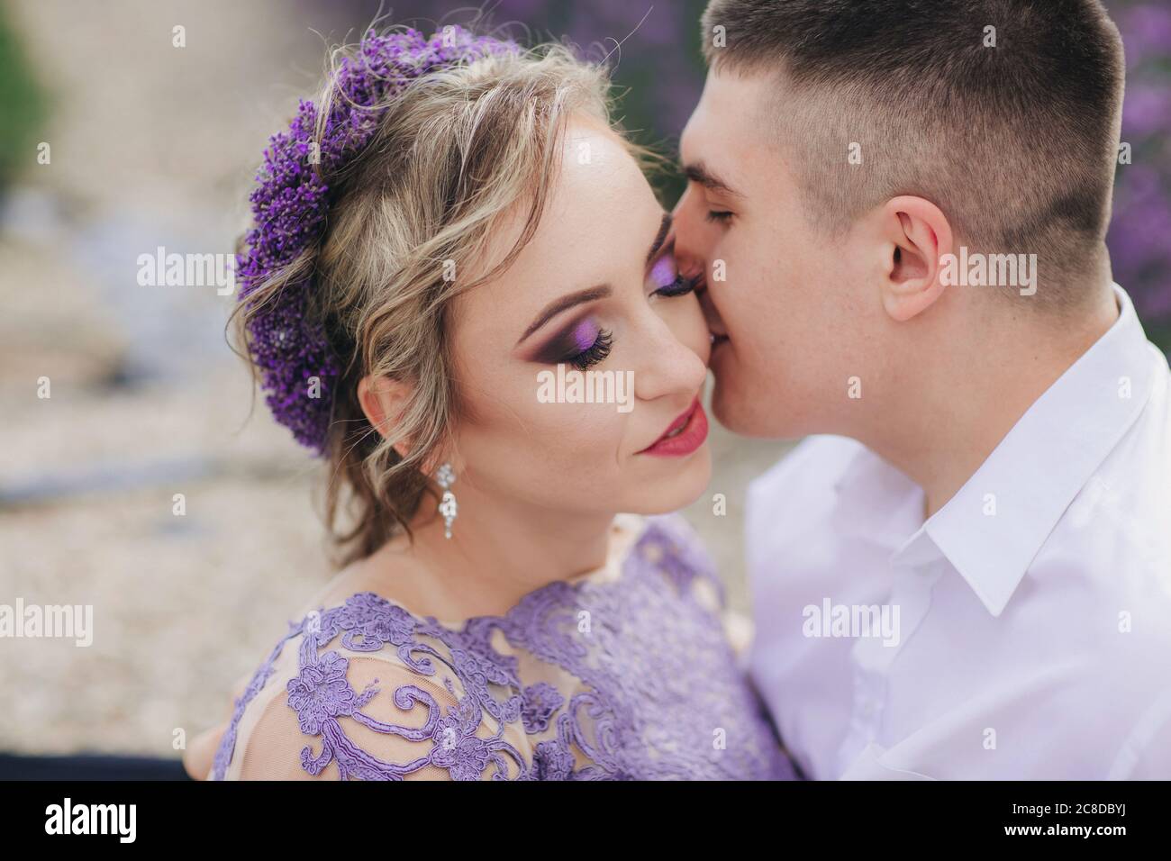 Young couple in love kissing in a lavender field on summer clody day. girl  in a luxurious purple dress and with hairstyle Stock Photo - Alamy