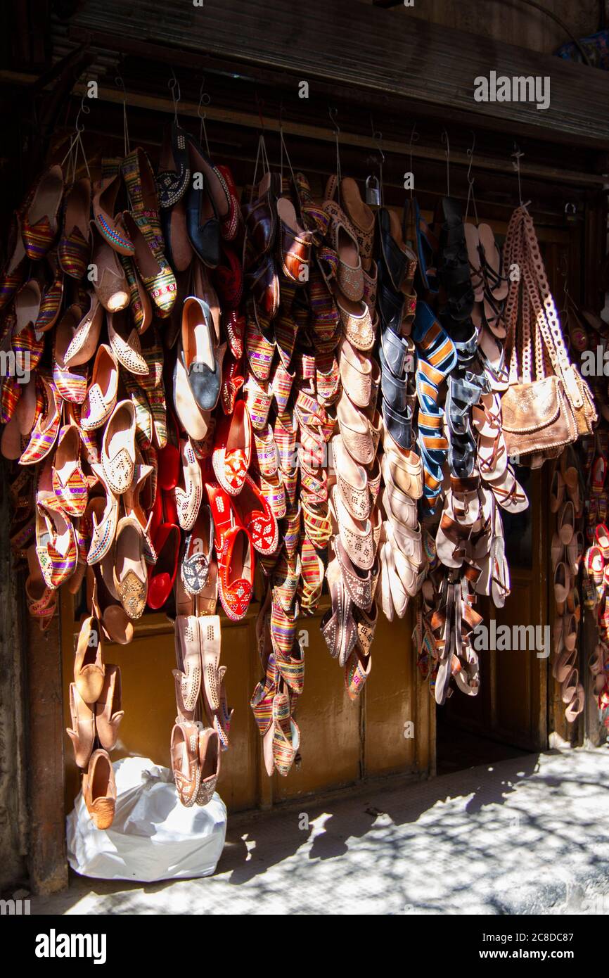 A storefront in central Damascus, Syria with an outdoor display of stacks of ethnic, local shoes and bags. The traditional bags and shoes are decorati Stock Photo