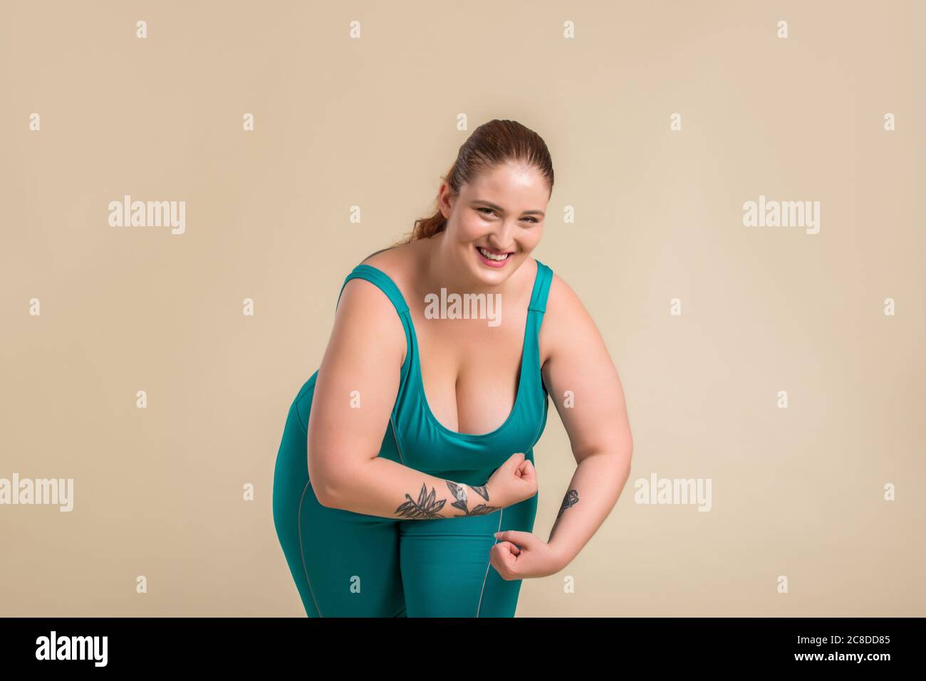 Pretty oversize woman wearing sportswear posing in studio - Beautiful girl accepting body imperfection, beauty shots in studio - Concepts about body a Stock Photo