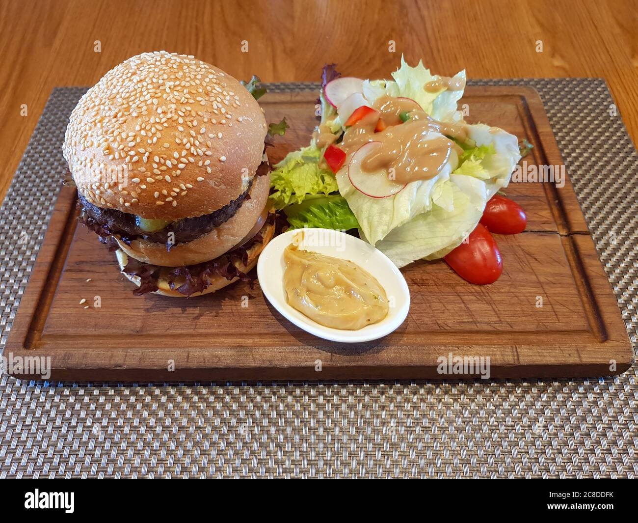 Double Cheeseburger Served On Wooden Plate At Restaurant Stock Photo