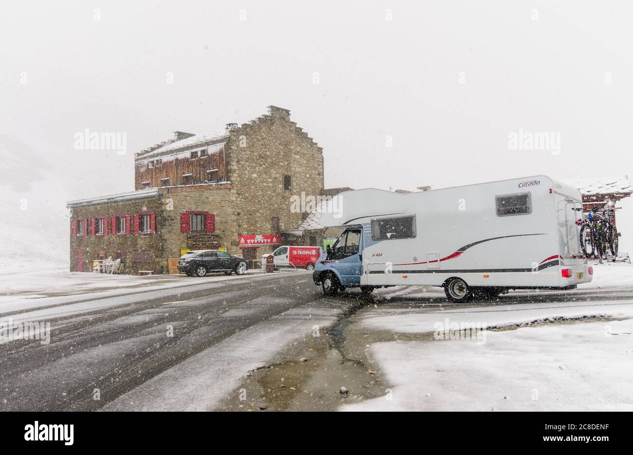 Camper on the top of Col d'Iseran in the French Alps, altitude 2770 m, in summer during snowfall. Stock Photo