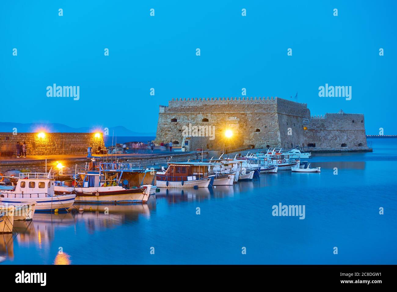 Fishing boats near the Koules Fortress in Heraklion at twilight, Crete island, Greece Stock Photo