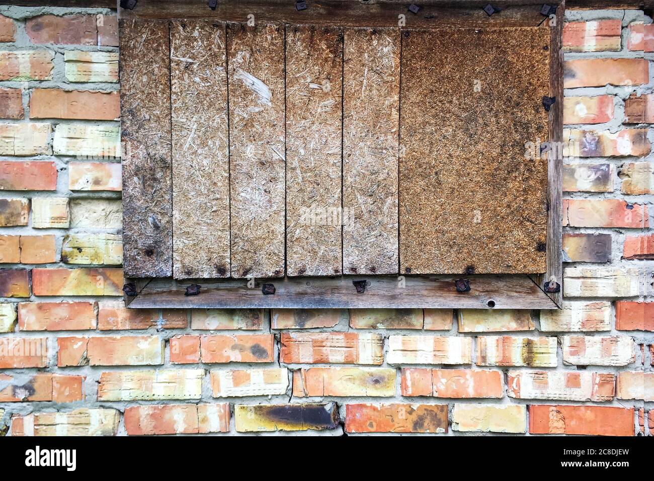Boarded up window in abandoned old brick wall in barn or closed old ...