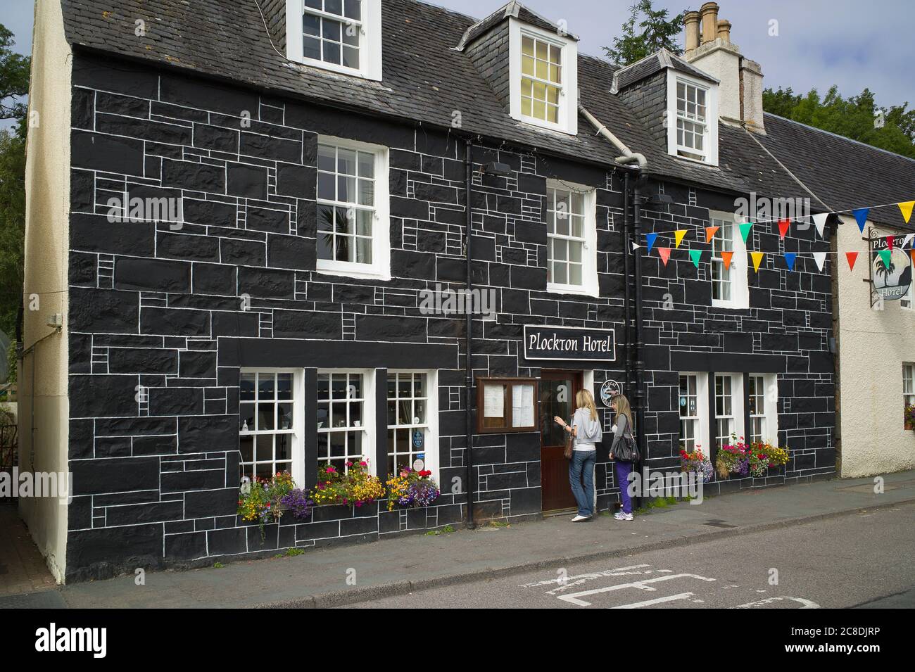 Female visitors entering the Plockton hotel in the Scottish Highlands UK in summer Stock Photo