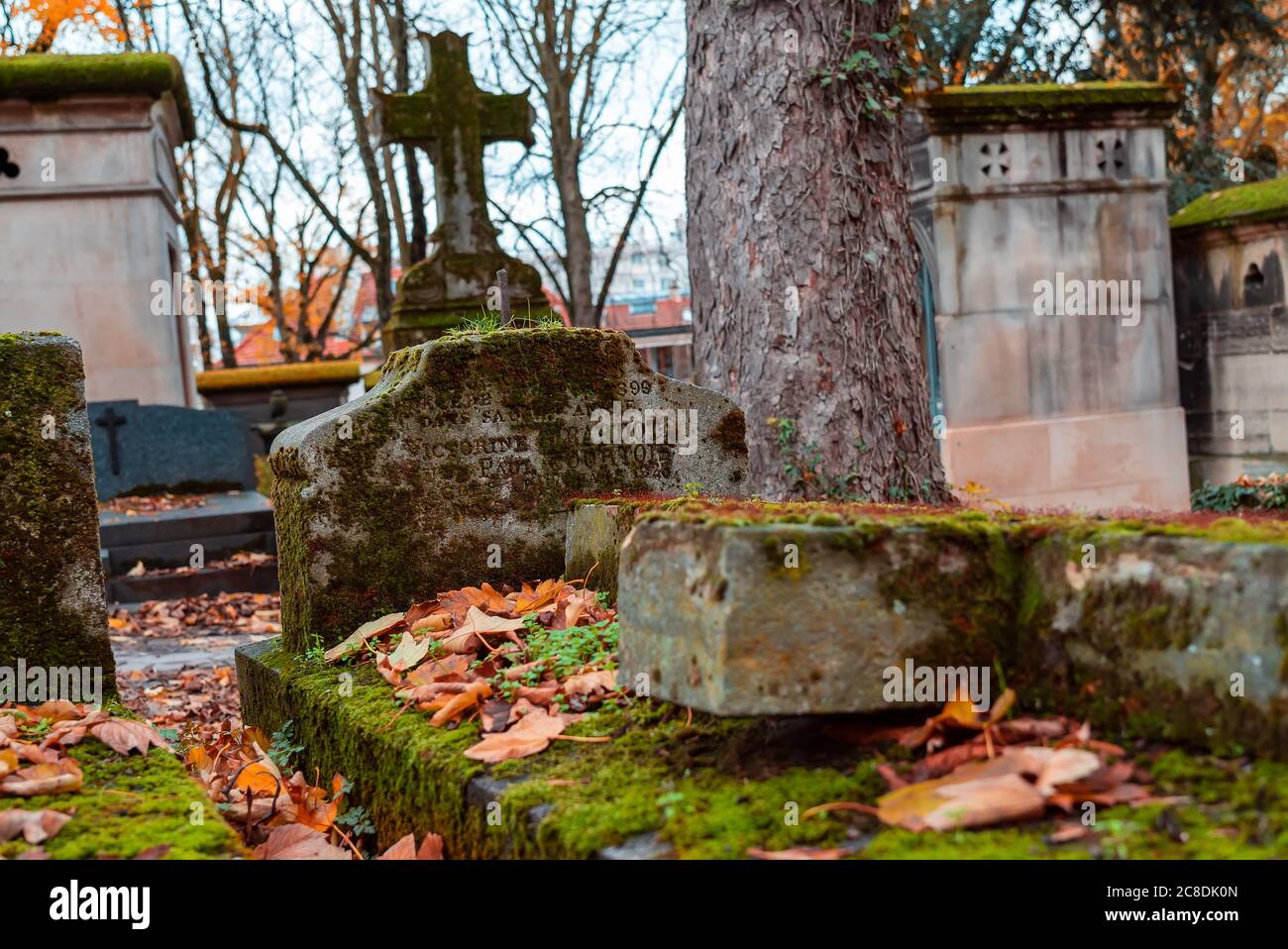 Paris, France - November 14, 2019: Stone cross in the most famous cemetery of Paris Pere Lachaise, France. Tombs of various famous people. Golden autu Stock Photo
