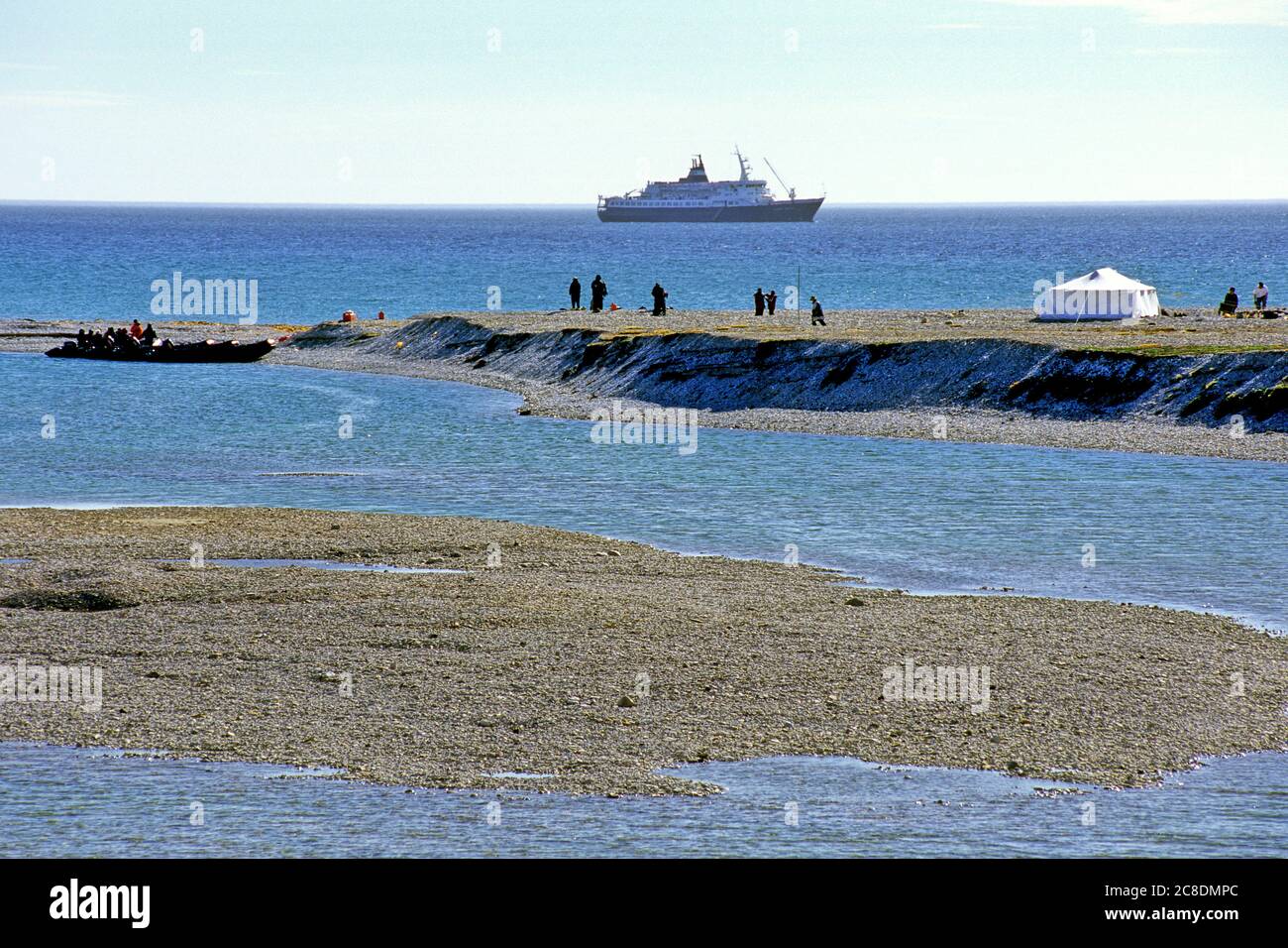 Inuit hunters in white tent with expedition ship ankered in front of Mansel Island, Nunavut, Canada Stock Photo