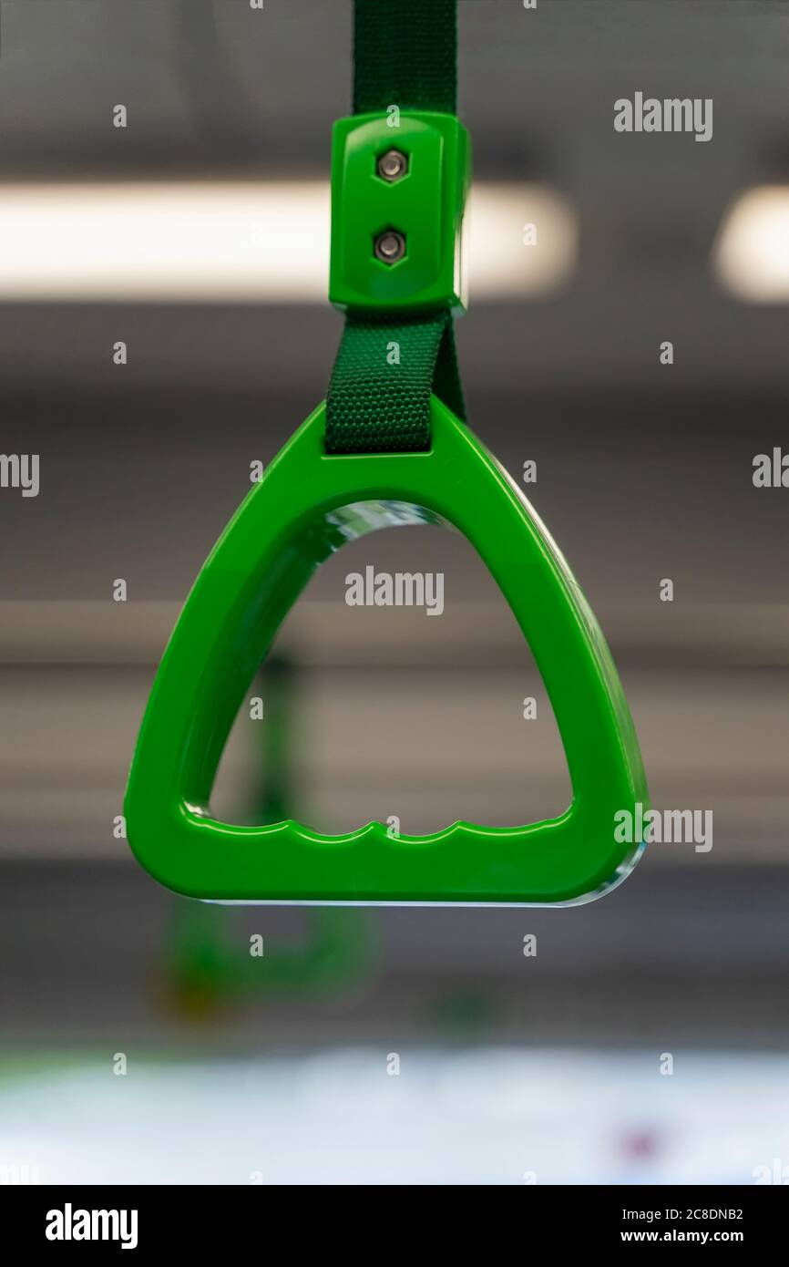 Green hanging handhold closeup for standing passengers, metro train, city transportation and safety concept Stock Photo