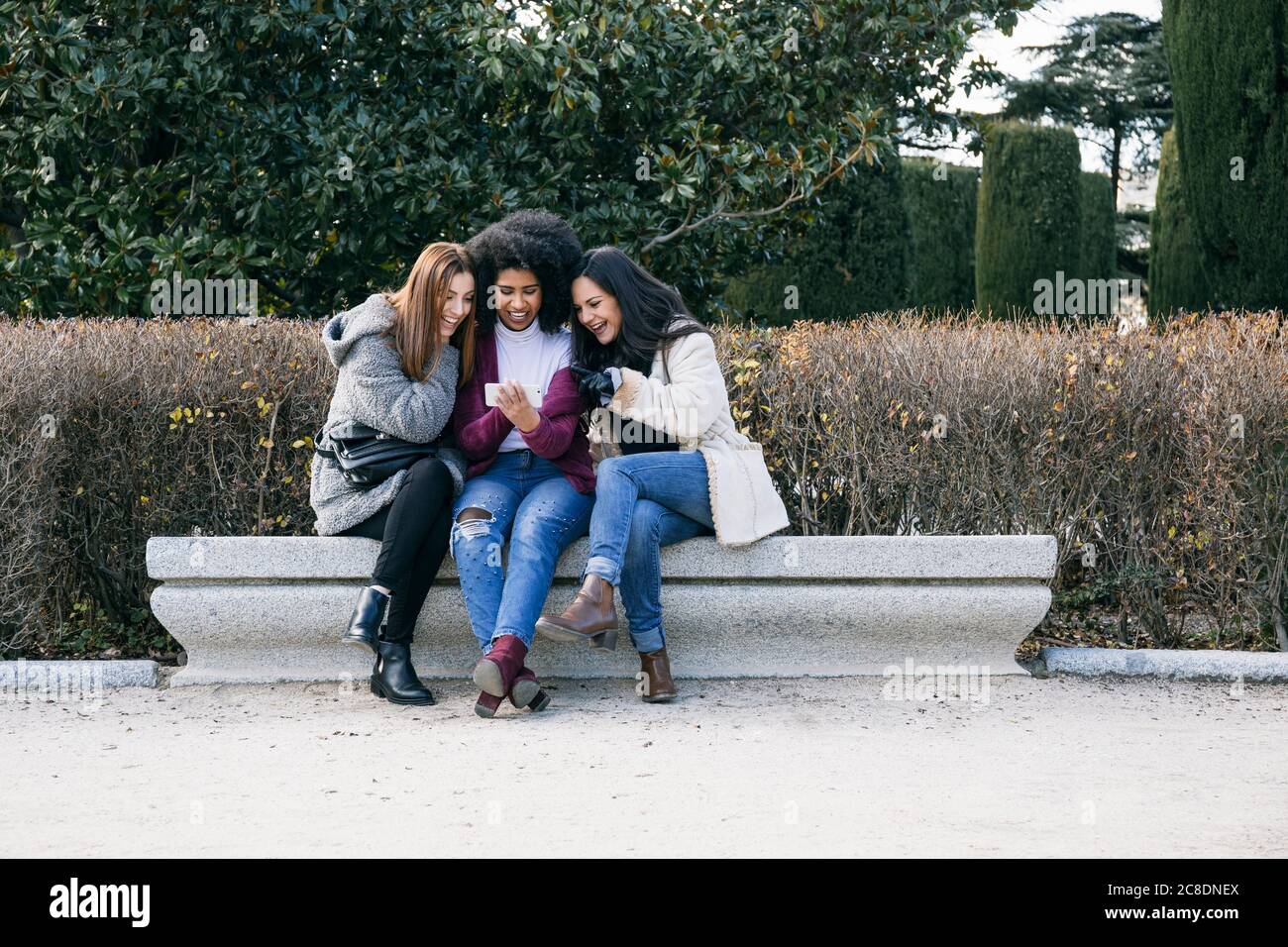 Group of friends sitting bench hi-res stock photography and images - Alamy