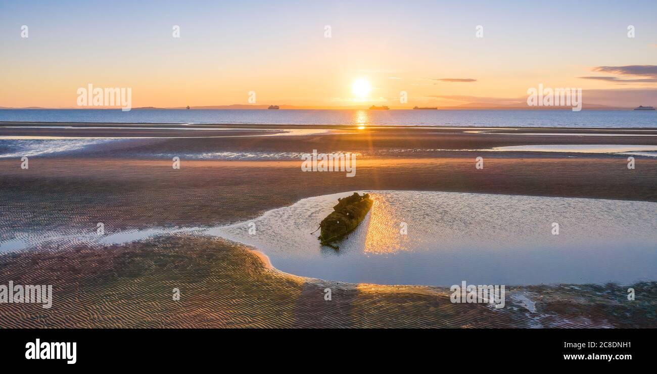 UK, Scotland, Wreck of X-Craft submarine lying on shore of Aberlady Bay at sunset Stock Photo